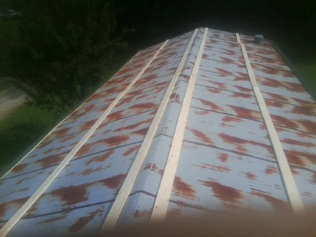 Rusted metal roof panels with new wood purlins before replacement — Storm Damage Roof Repair in Haswell by Roofing Brothers